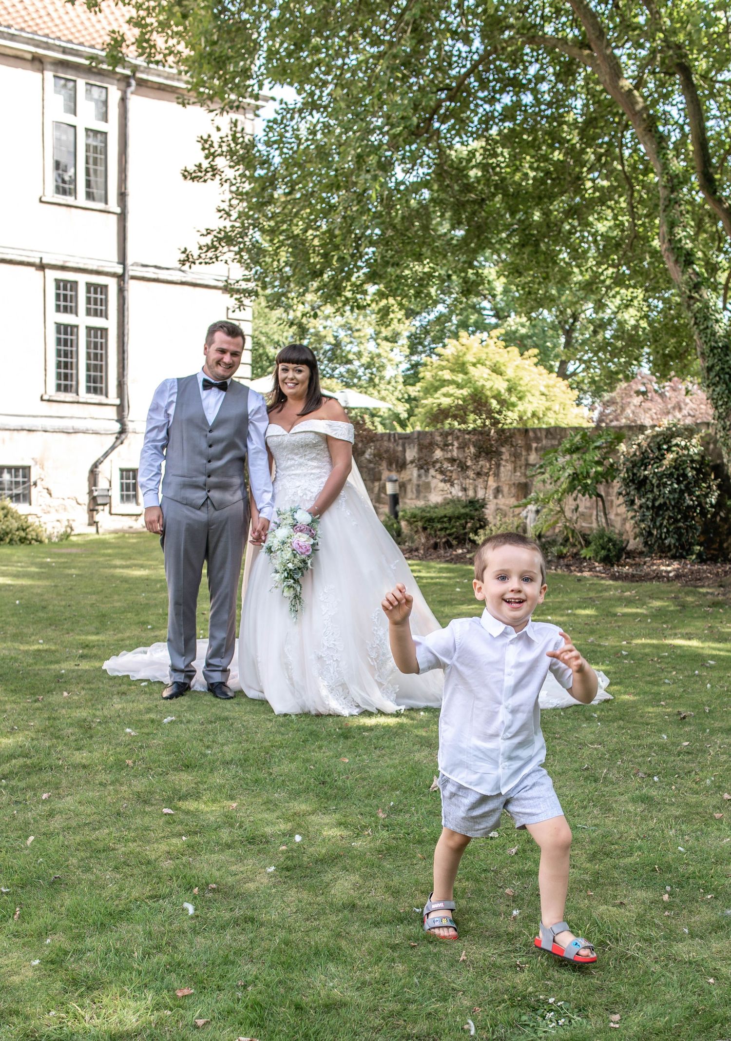 A joyful wedding portrait in a garden setting with playful energy.