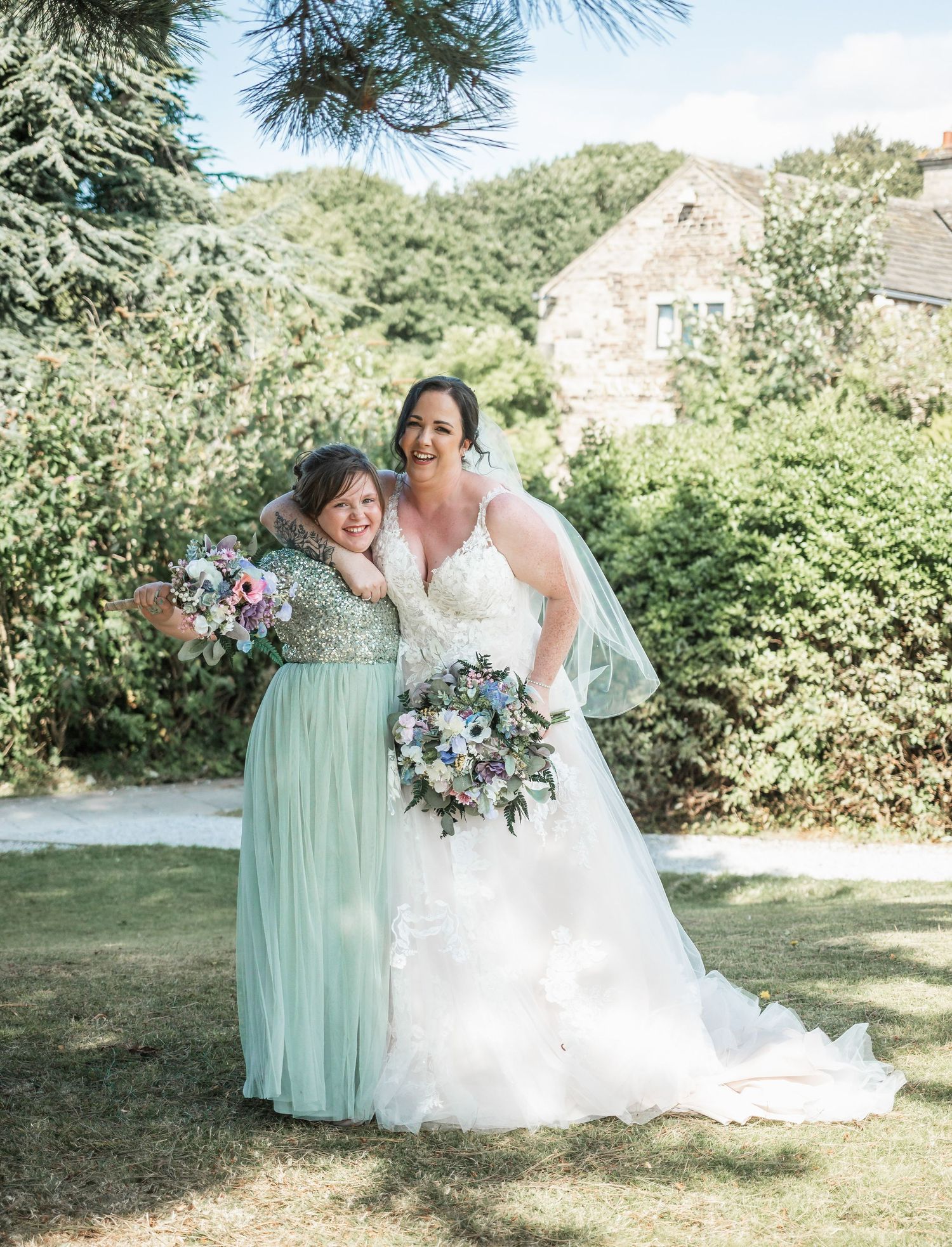 Outdoor wedding portrait in garden setting with mint green bridesmaid dress and elegant bouquets.