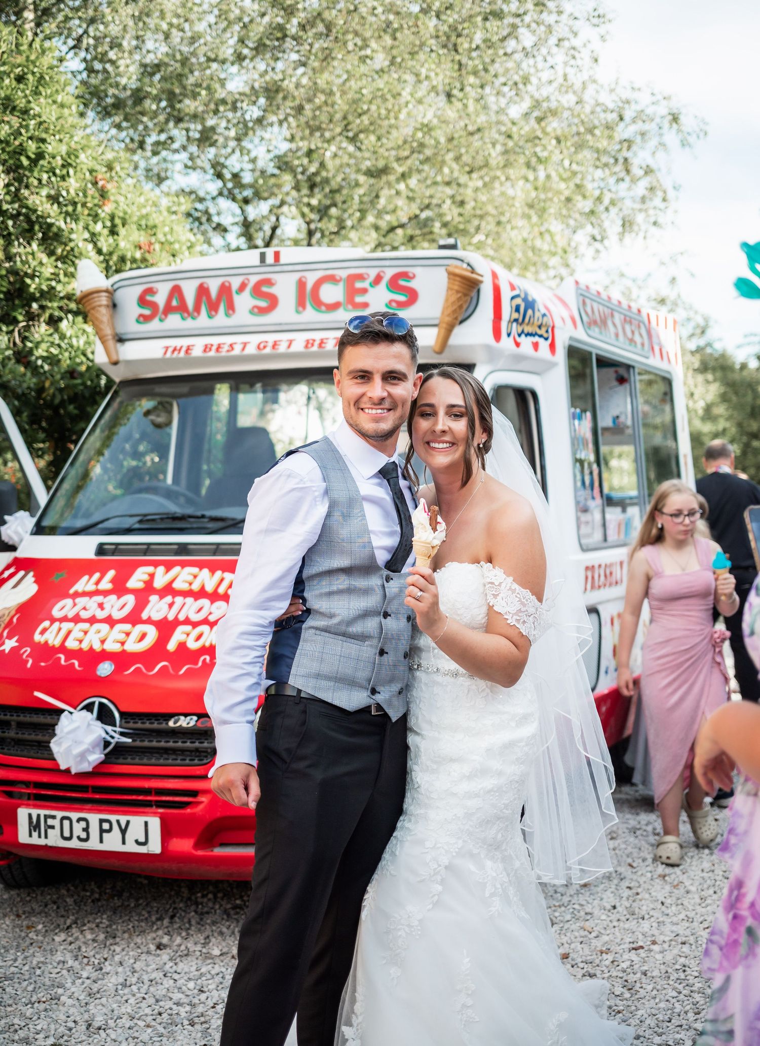 Wedding couple enjoys ice cream by vintage Sam's Ices truck on their special day.