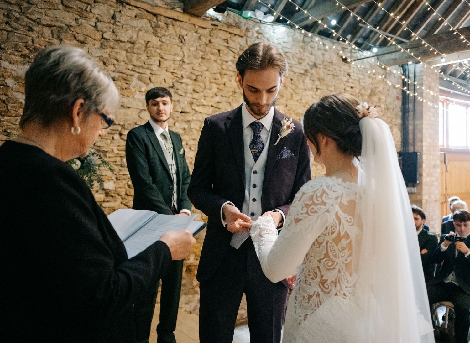 Wedding guests gather in a rustic brick venue during a celebration reception.