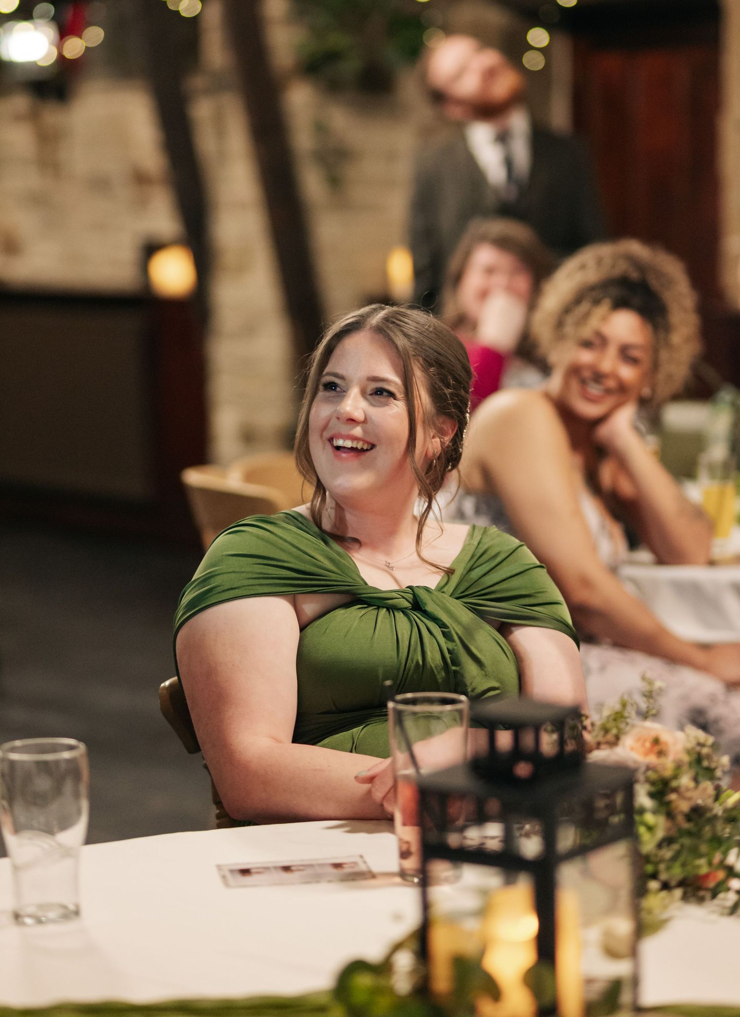 Wedding guests in green attire enjoying the reception dinner and festivities.