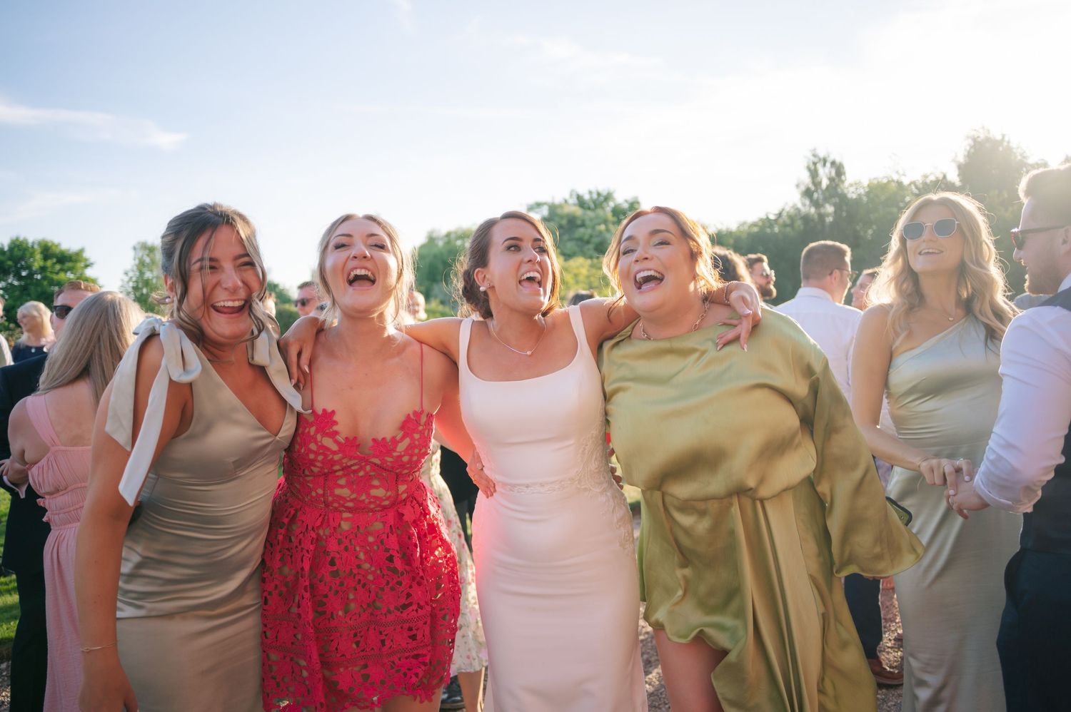 Wedding guests celebrating outdoors in colorful summer attire.