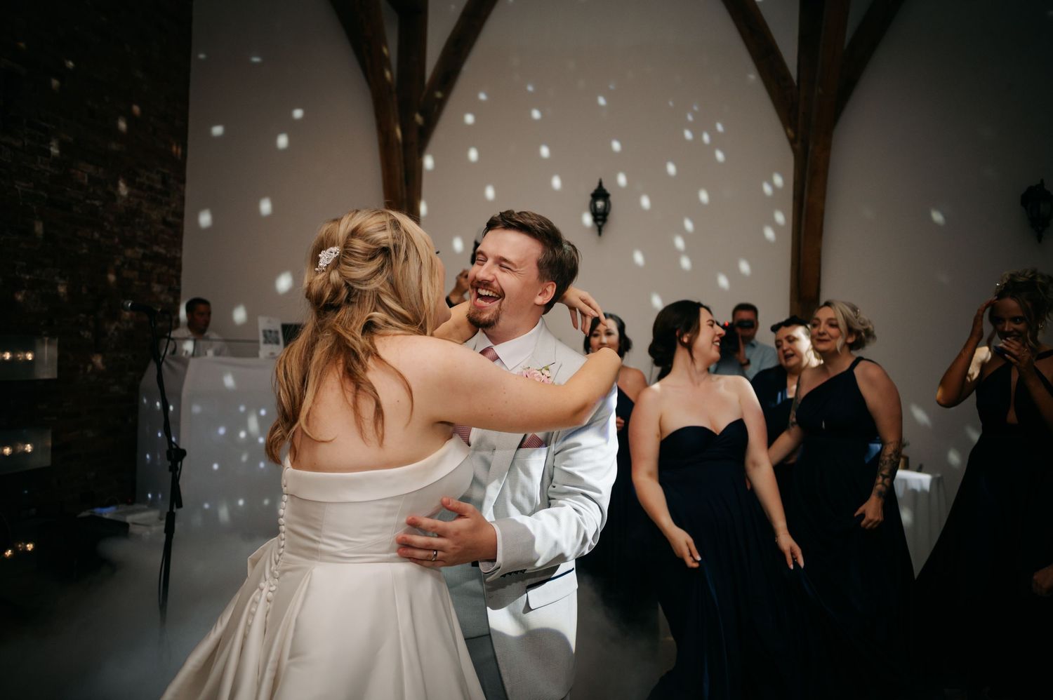 Couple dancing in an intimate moment under twinkling lights at their wedding reception.