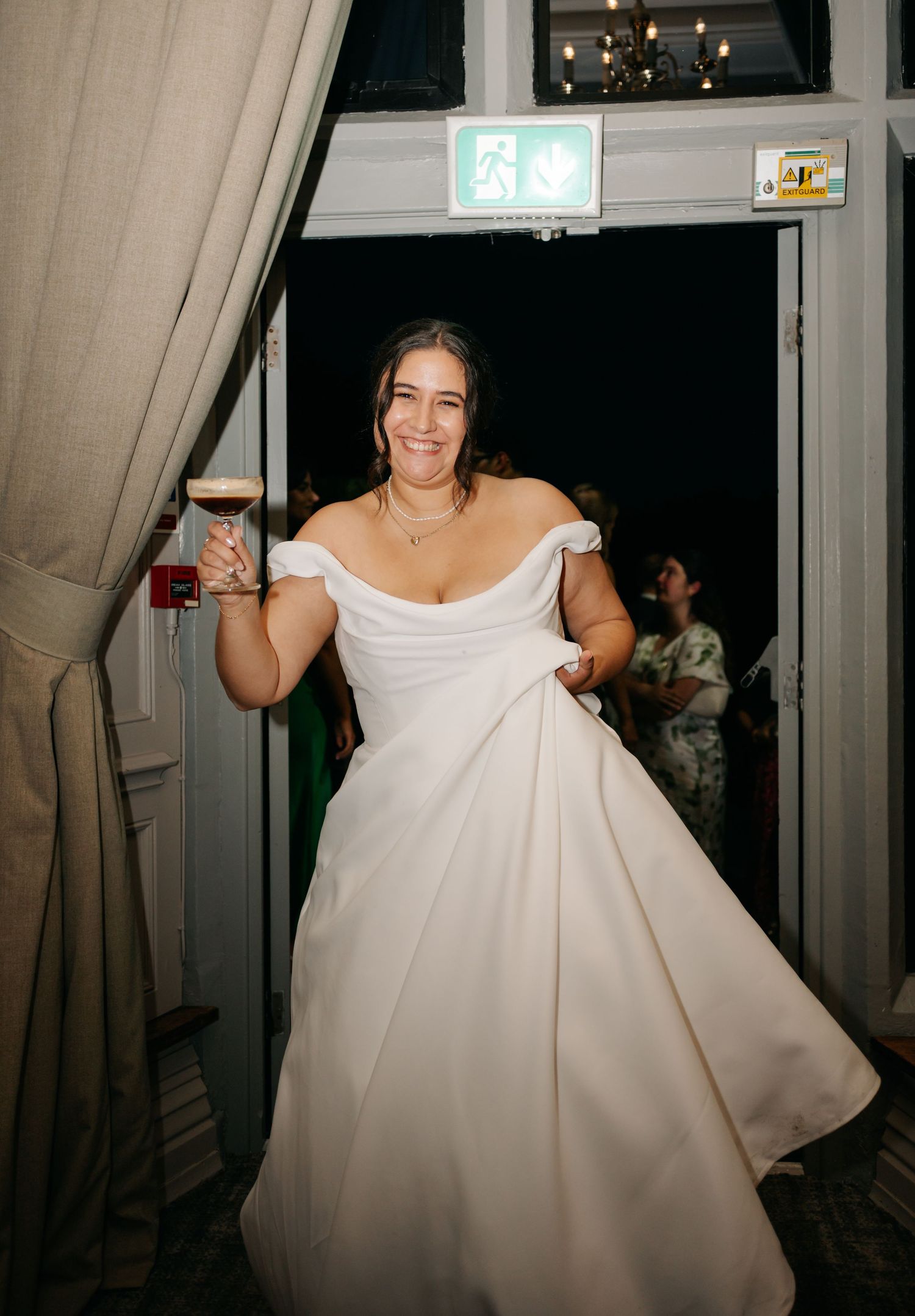 Bride twirls in elegant white wedding gown during evening reception celebrations.