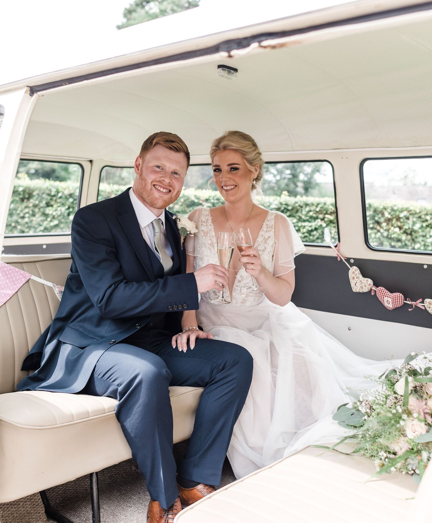 Wedding couple sitting together in a vintage cream-colored van.