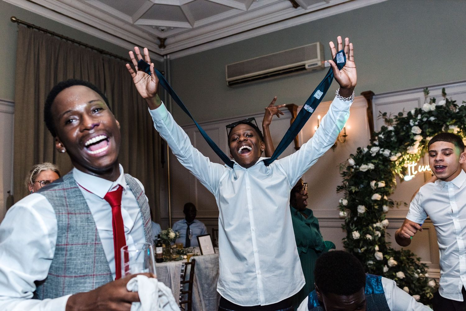 Party guests cheering with raised arms during a lively celebration.