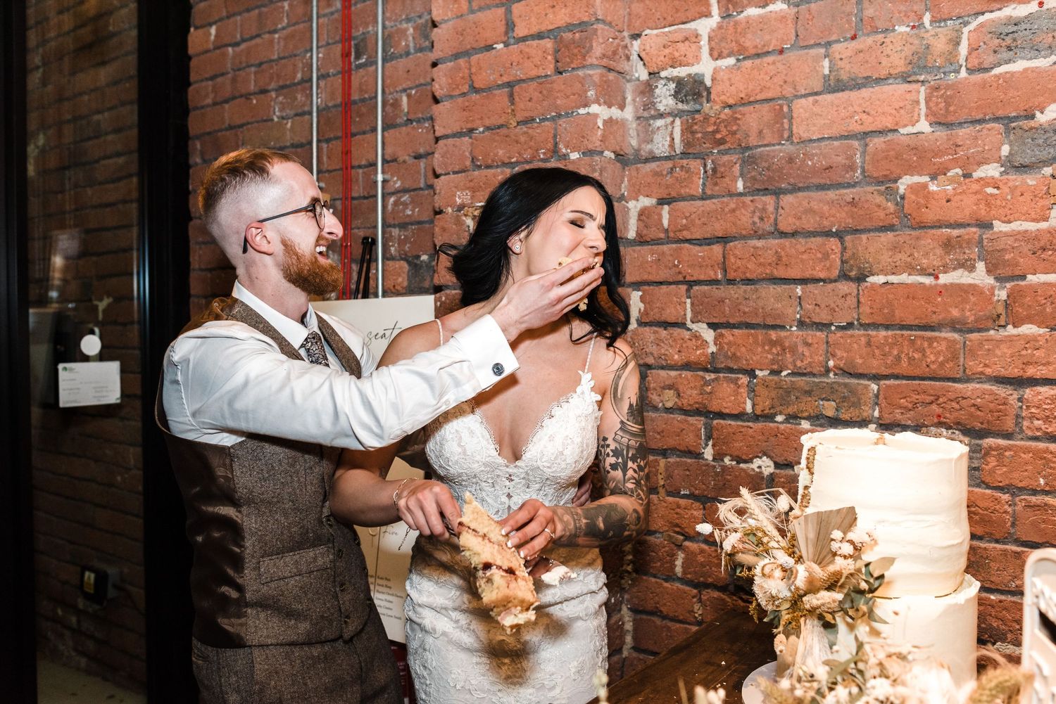 A wedding celebration moment captured against an exposed brick wall with pendant lighting.