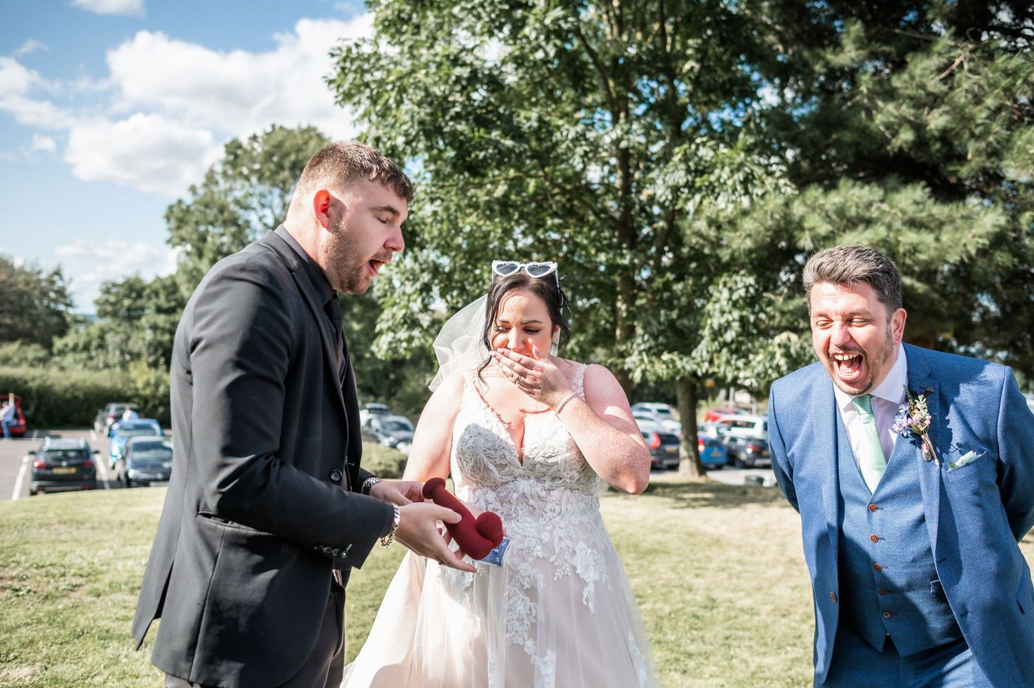 Wedding guests share a lighthearted moment during an outdoor summer celebration.