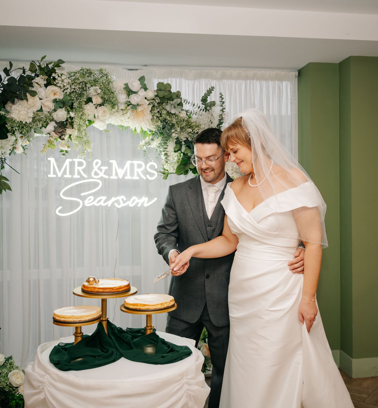 Wedding cake display with Mr & Mrs signage and floral decorations.