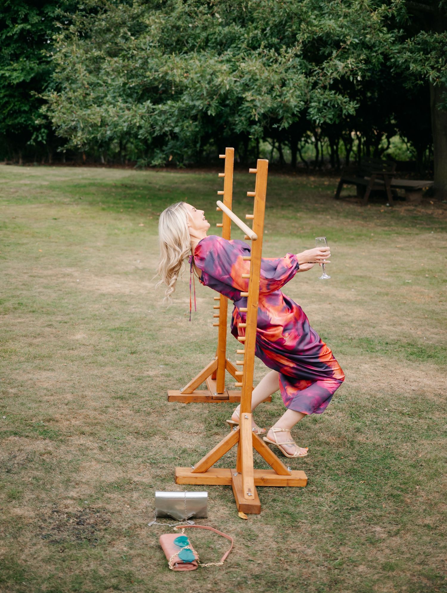 Child playing outdoor garden games with wooden posts on grassy lawn.