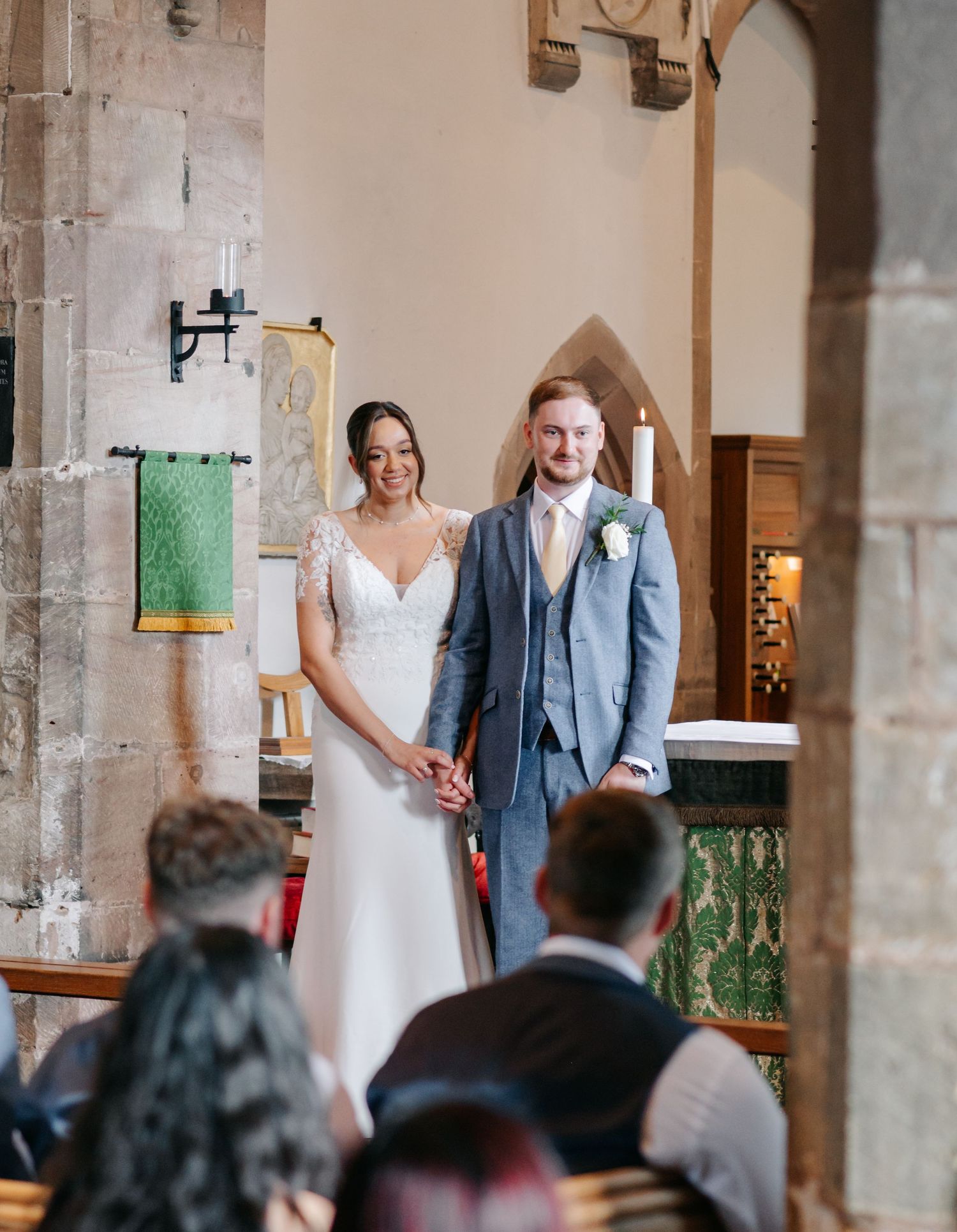 Wedding ceremony in a historic stone church with architectural columns.