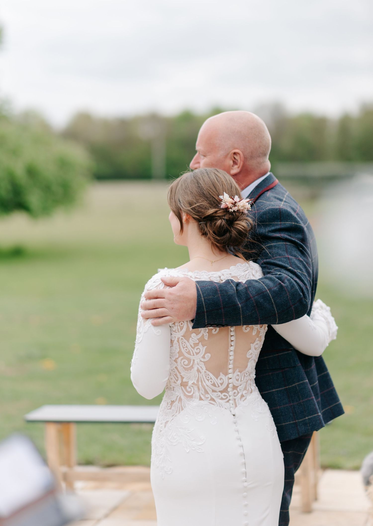 Romantic first look moment between couple in wedding attire outdoors in a field.
