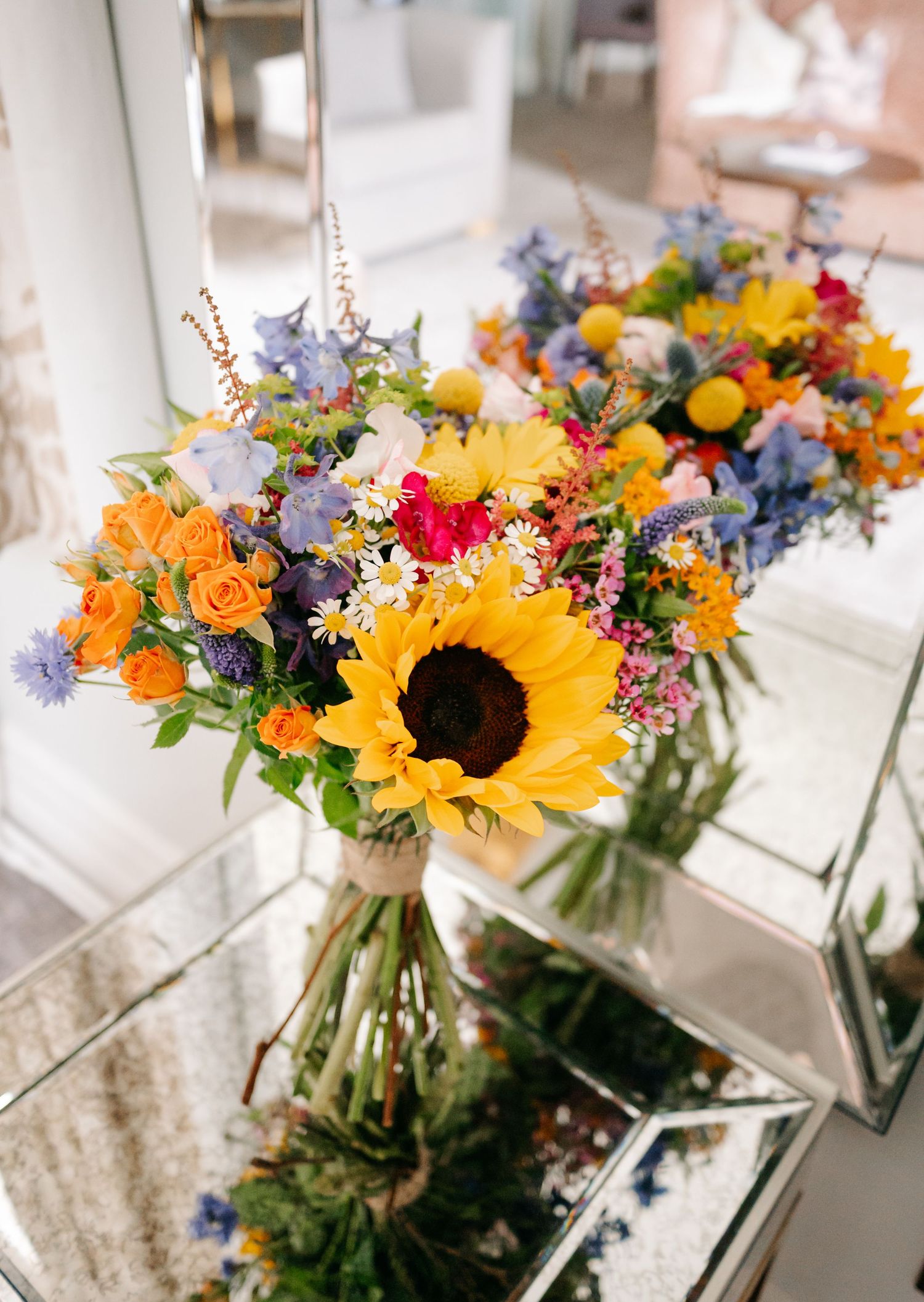 Bright sunflowers and wildflowers arranged in glass vases create a cheerful summer wedding display.