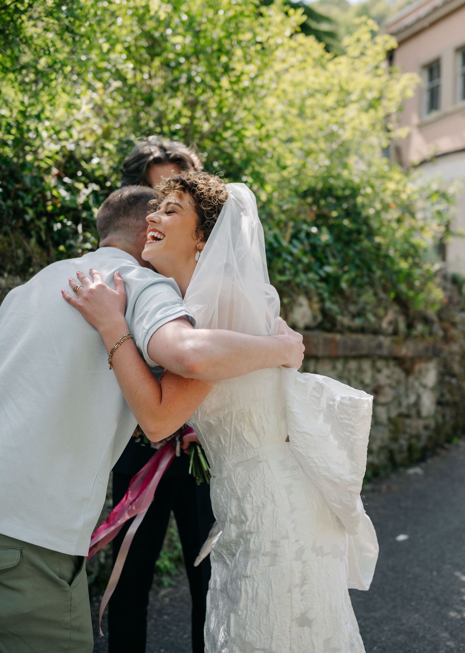 Candid wedding photos show joyful embraces and laughter in an outdoor garden setting.