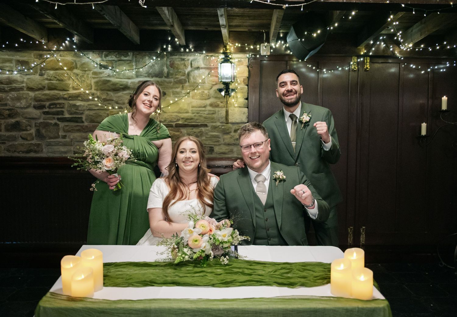 Wedding reception celebration in a rustic stone venue with string lights overhead.