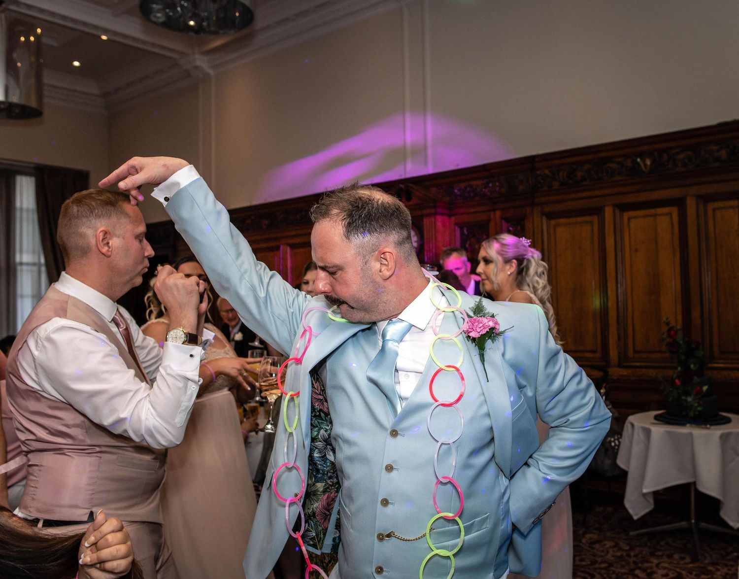 Two guests sharing a fun moment on the dance floor at a wedding reception.