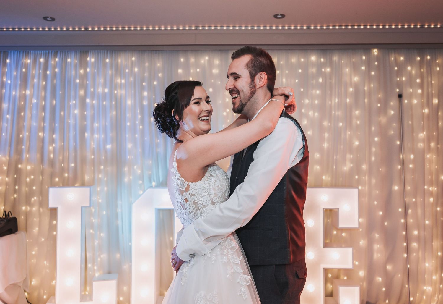 Wedding reception party scene with twinkle lights and dancing.