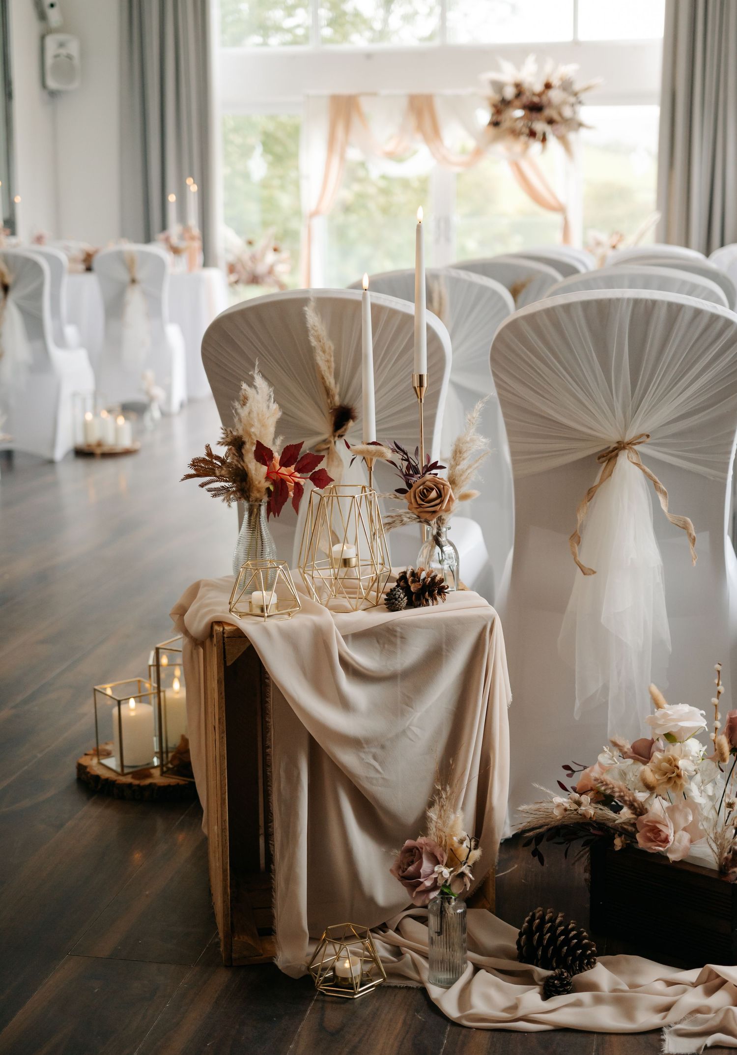 Elegant wedding reception table setup with white chair covers and romantic candle centerpieces.