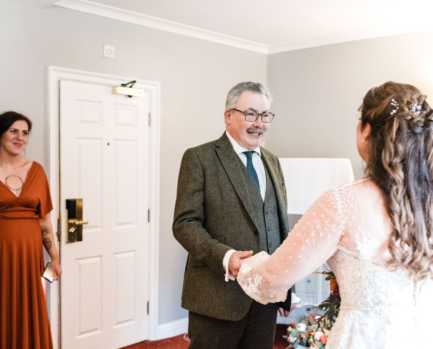 Sweet first look moment between bride and older man in tweed suit.