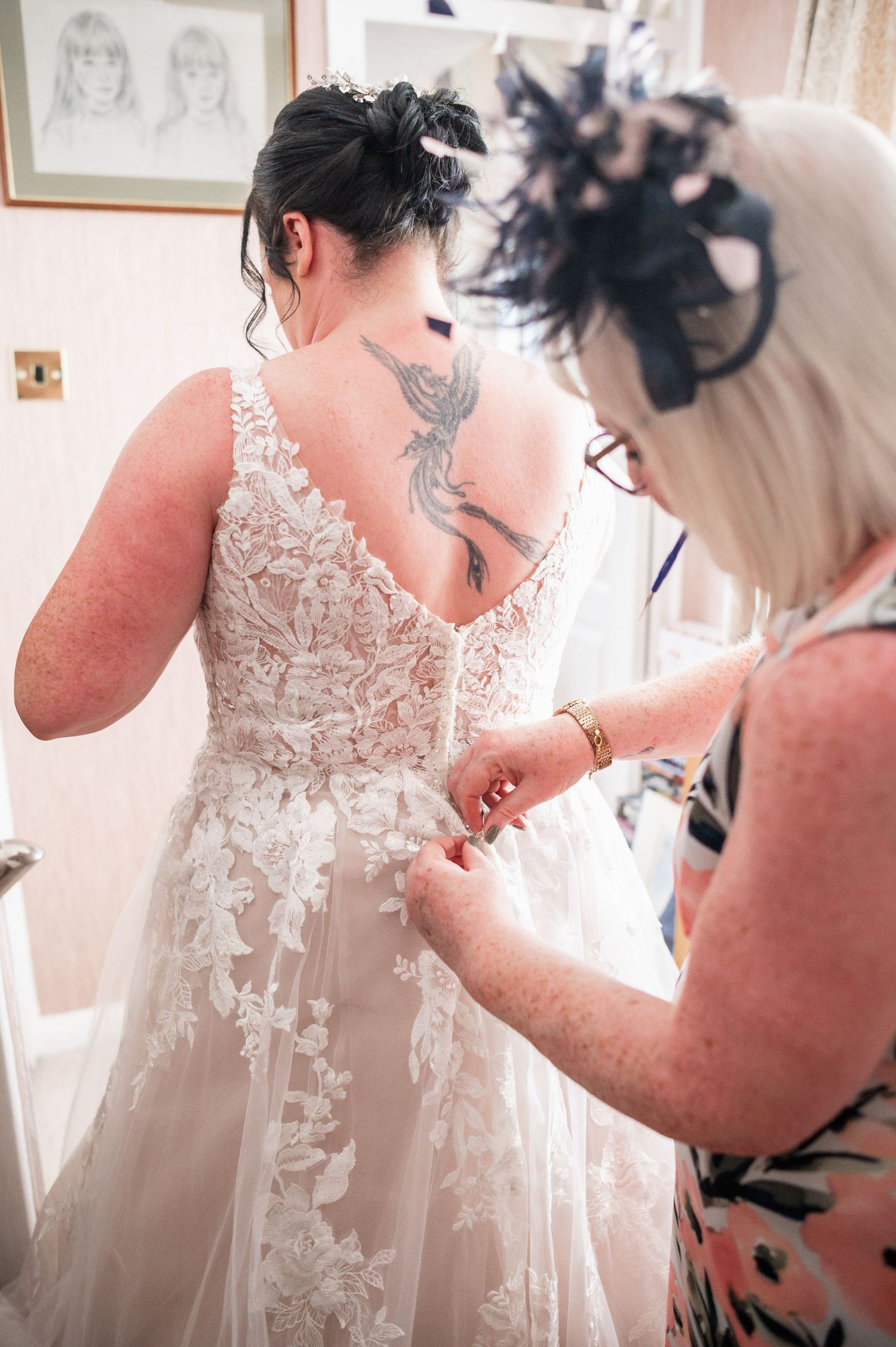 Close-up detail of intricate lace wedding dress being adjusted.