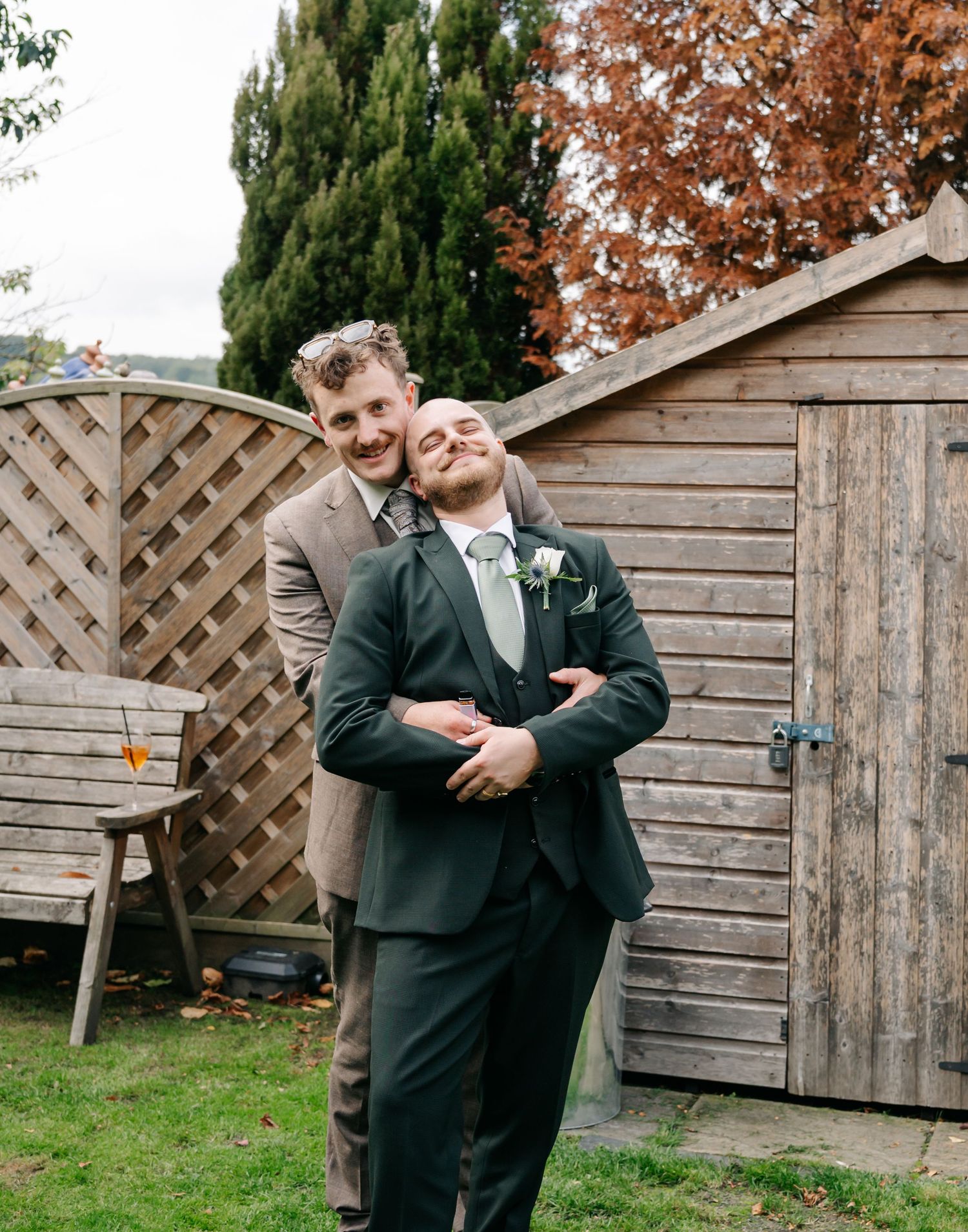 Candid moments captured against a wooden fence backdrop during wedding celebrations.