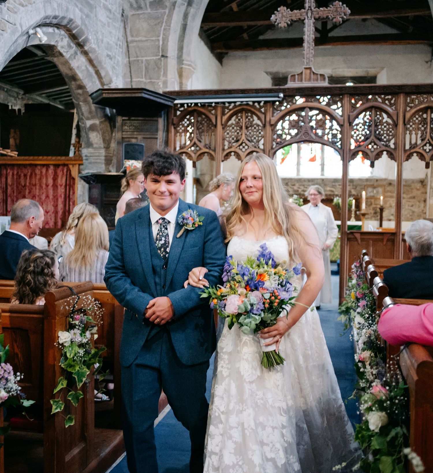 Wedding ceremony moments captured inside a historic church with ornate wooden details.