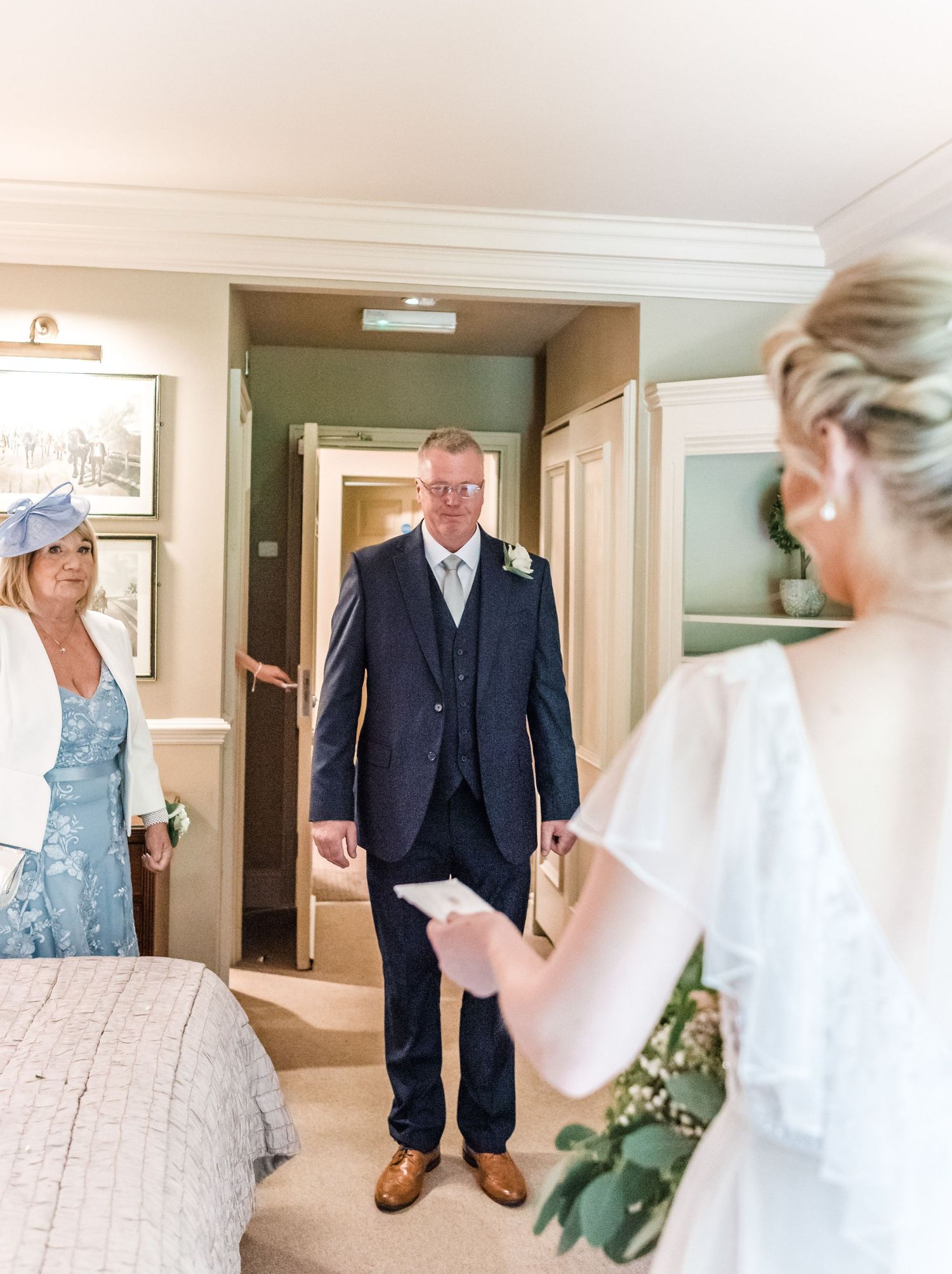 A pre-wedding scene shows intimate moments of getting ready in an elegant hotel room.