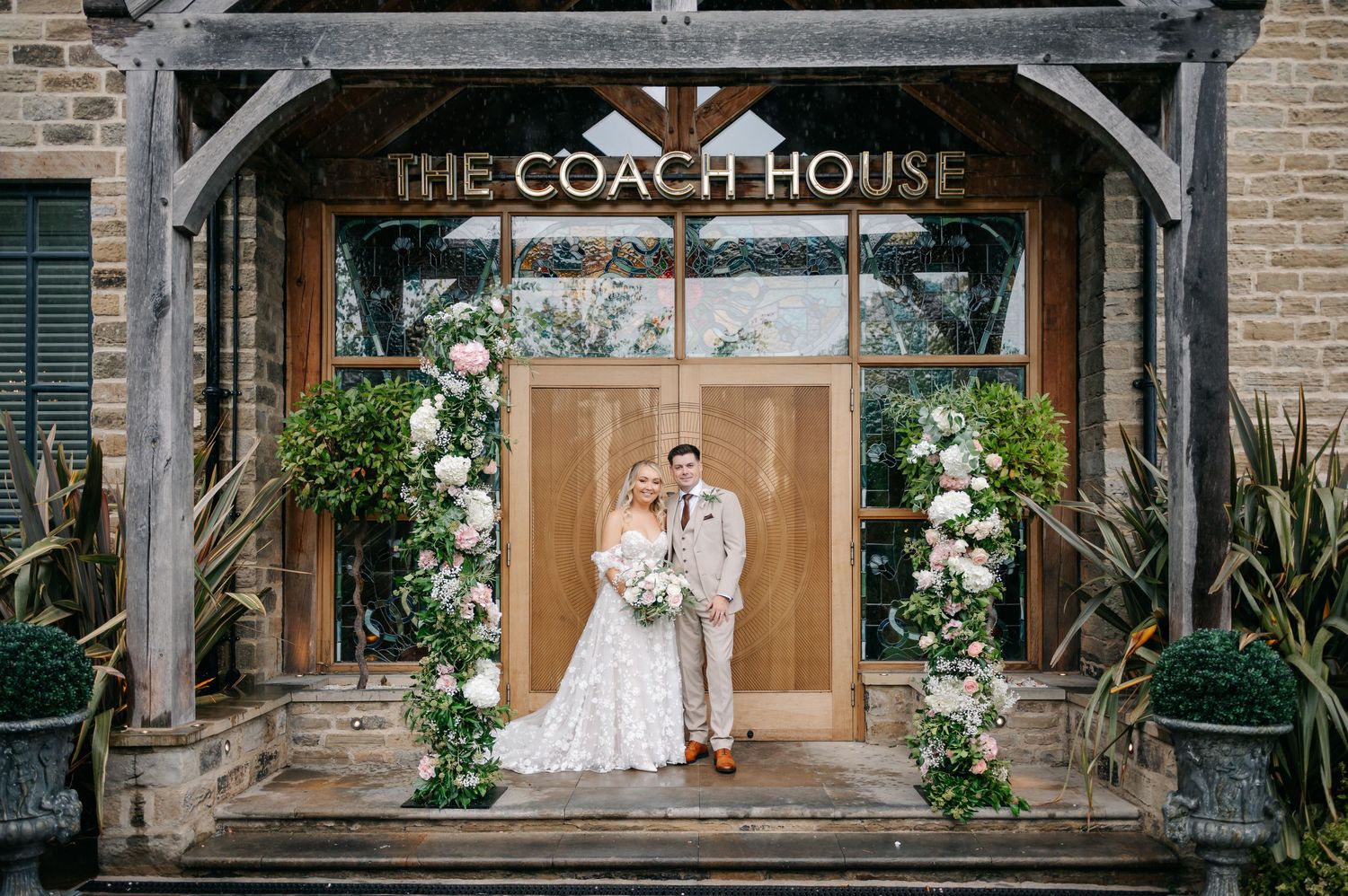 A wedding venue called The Coach House with exposed brick walls and elegant floral arrangements.