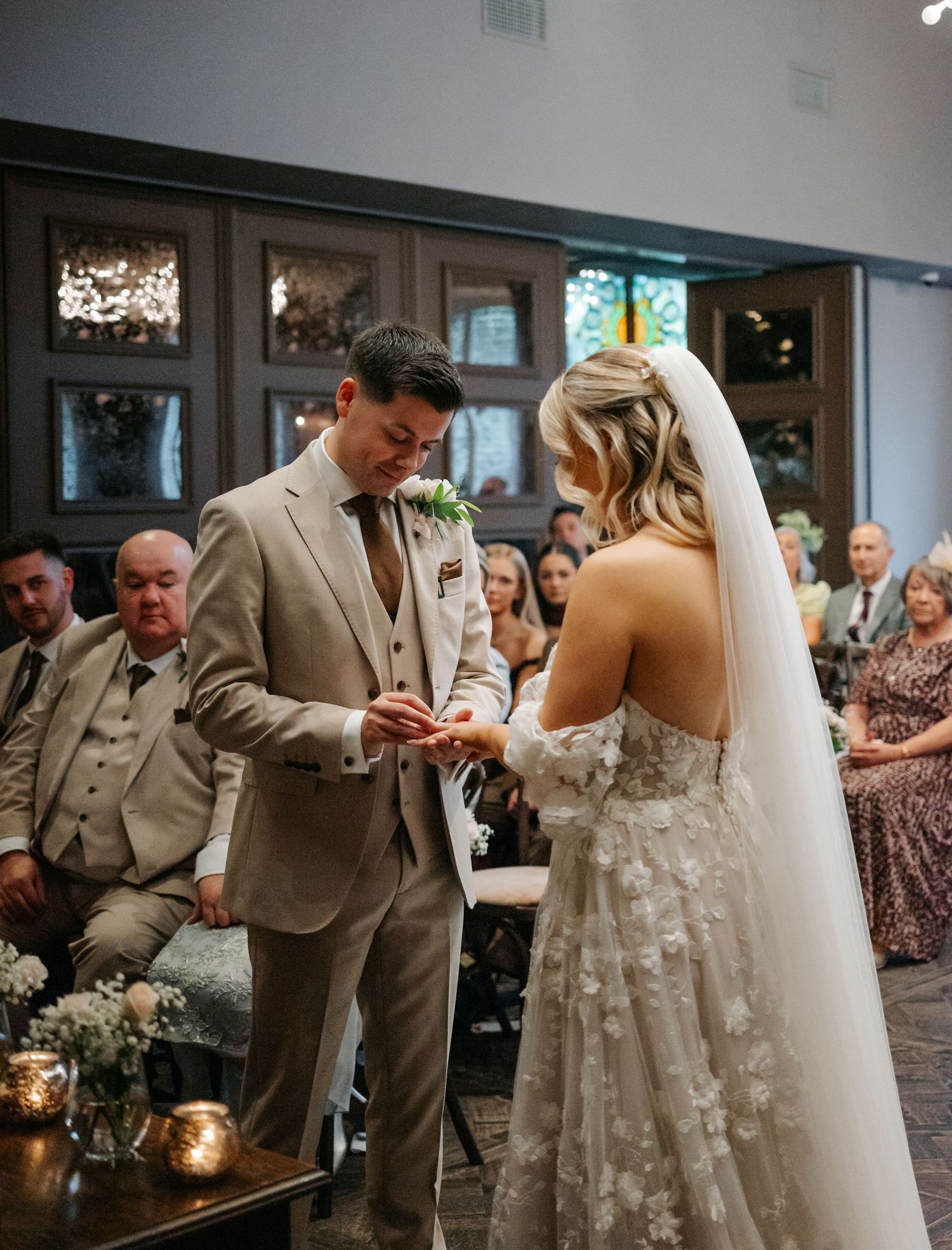 Wedding ceremony moments in an elegant indoor venue with floral decorations.