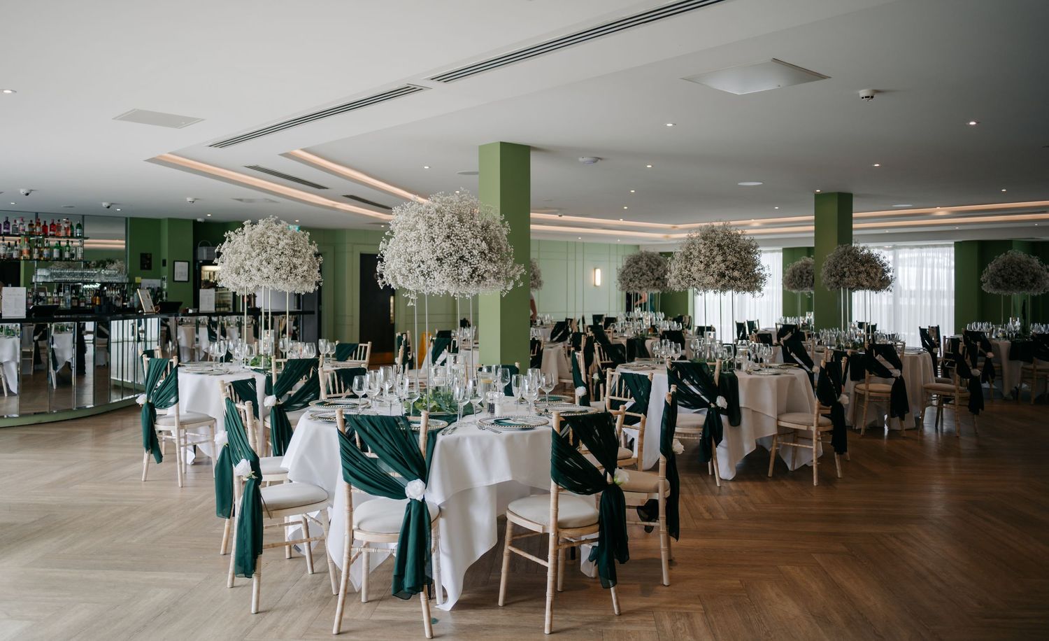 Panoramic view of an elegant wedding reception venue with green accents.