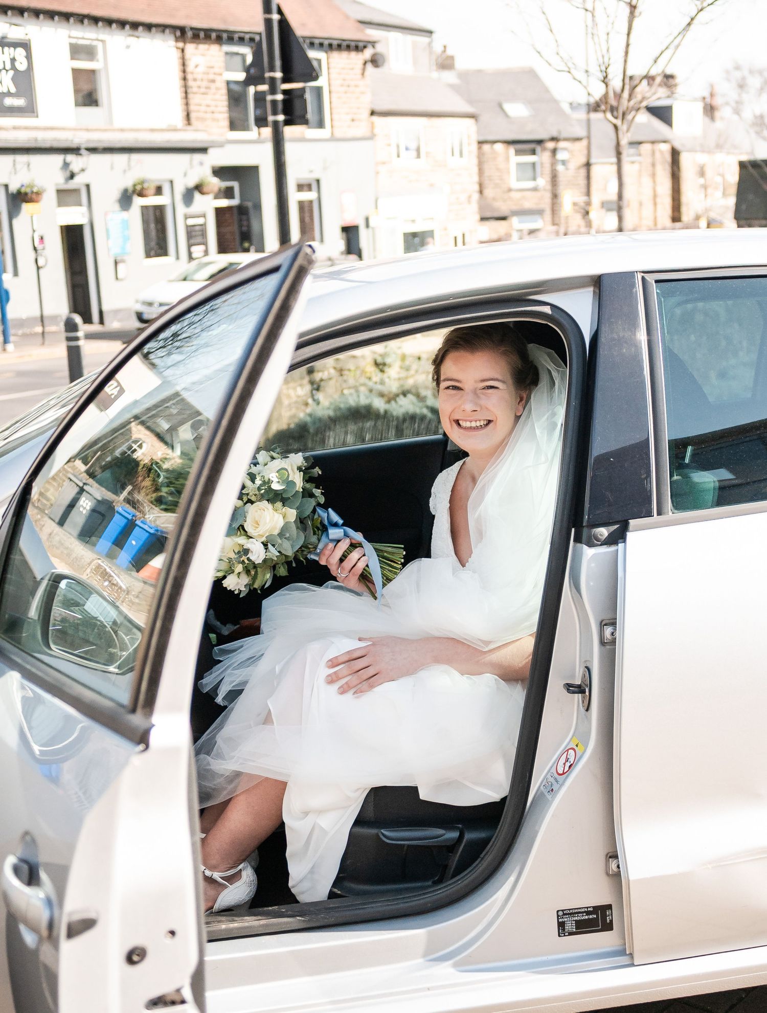 Wedding couple shares joyful moments inside a vintage car during their special day.
