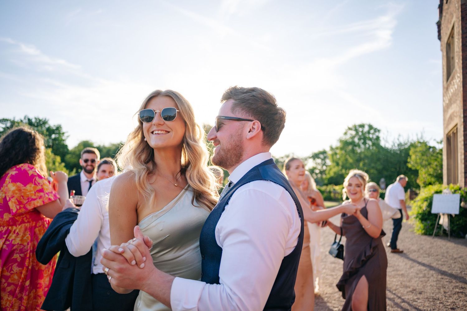 Outdoor wedding celebration with guests enjoying a sunny afternoon.