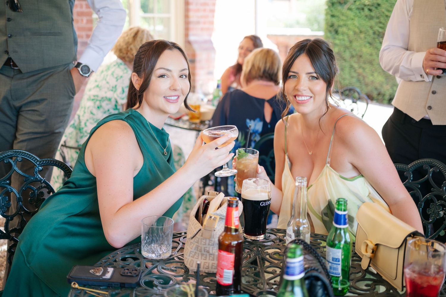 Wedding guests enjoying drinks and conversation at outdoor reception.
