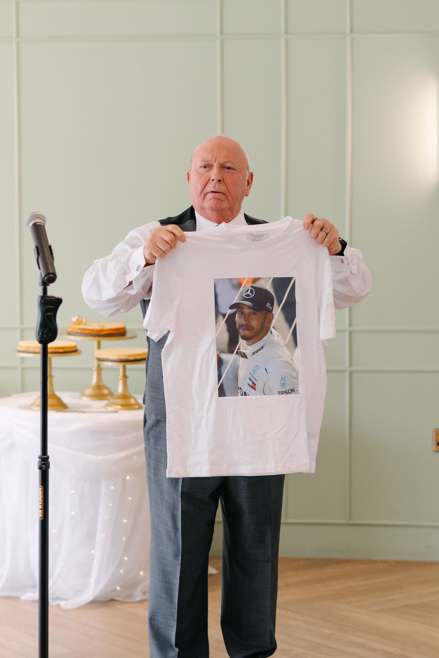 A sequence of someone holding up and displaying white dress shirts in a bright indoor space.