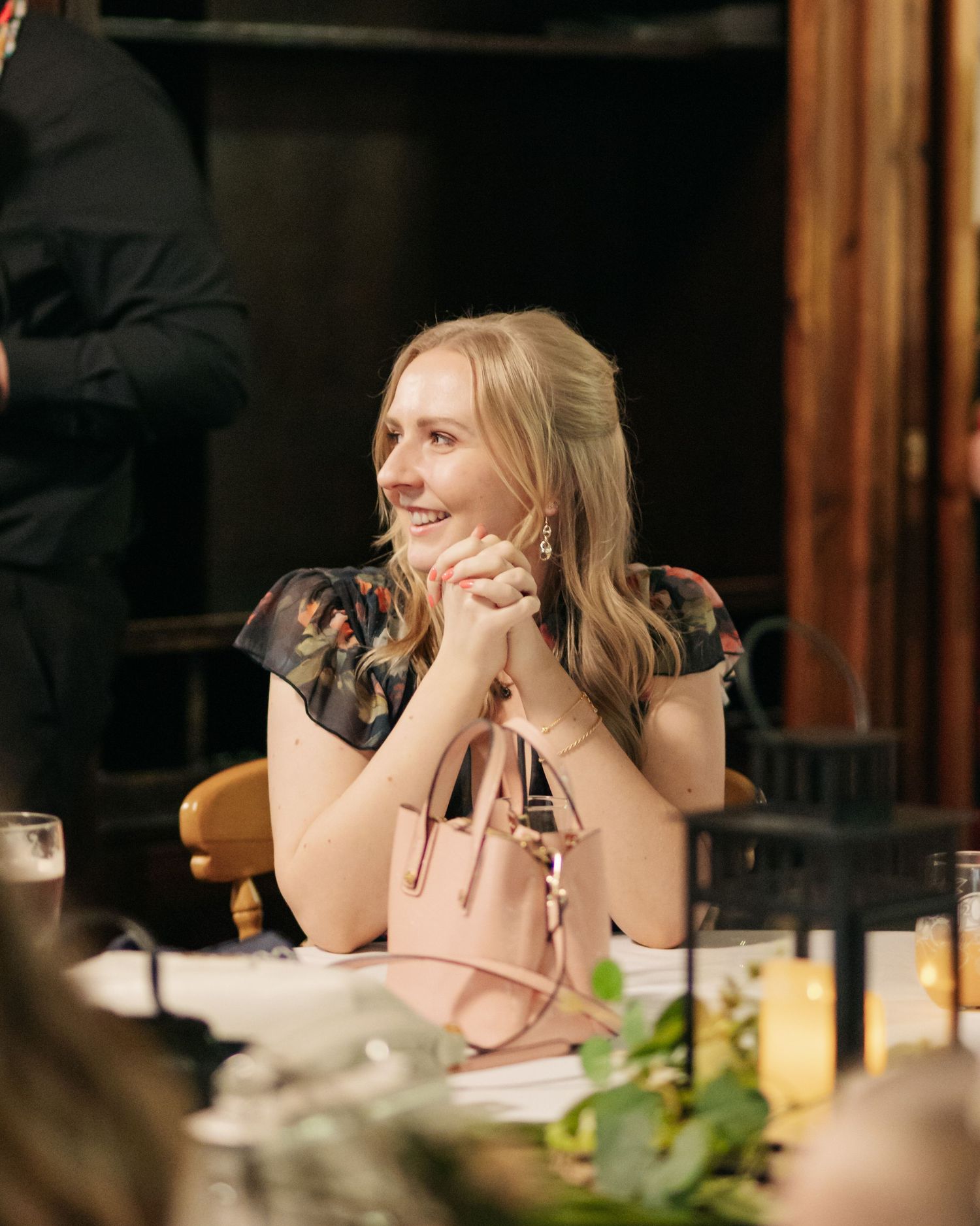 Natural candid reactions during an intimate dinner gathering with soft ambient lighting.