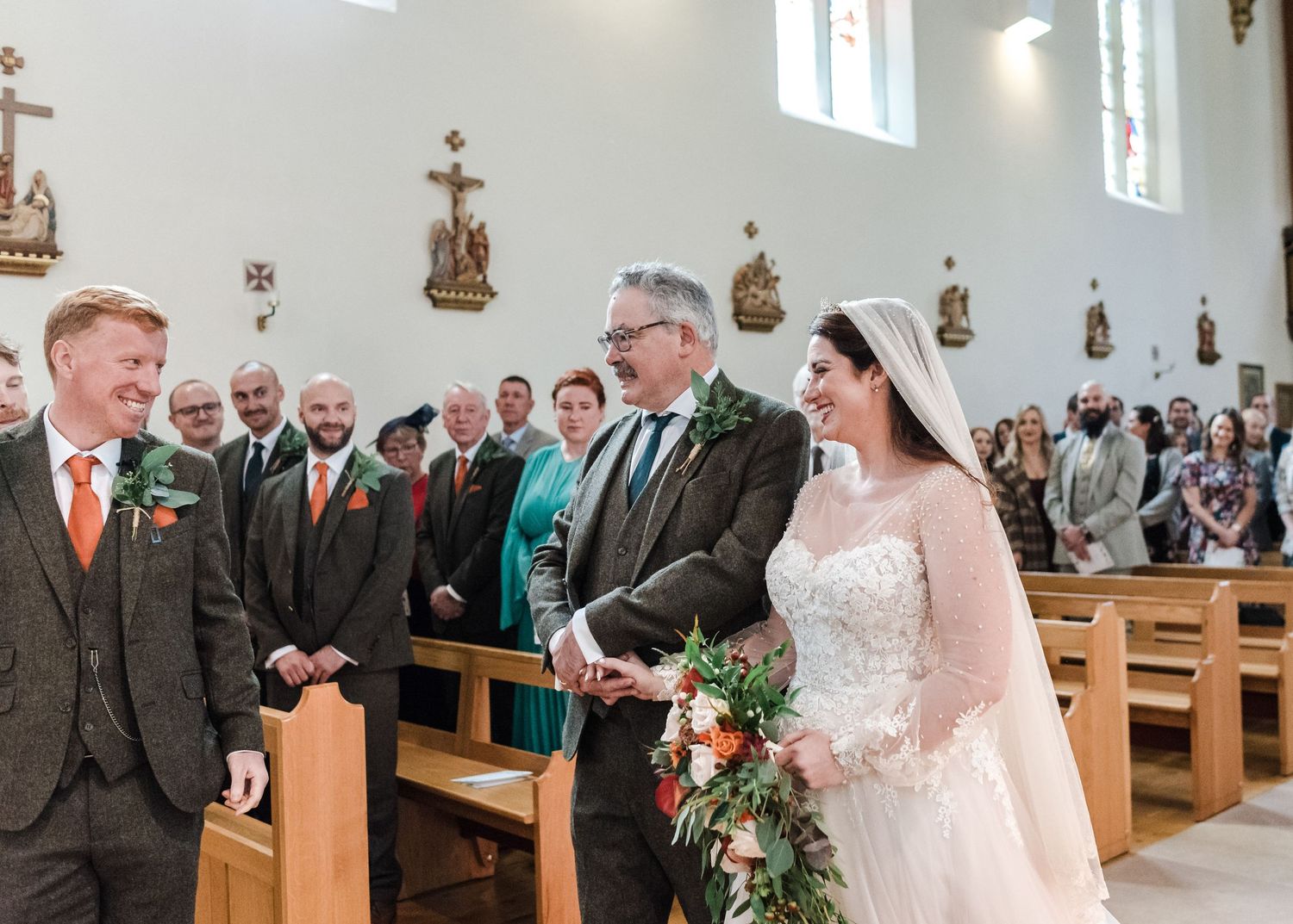 Beautiful church wedding ceremony with guests seated in wooden pews.