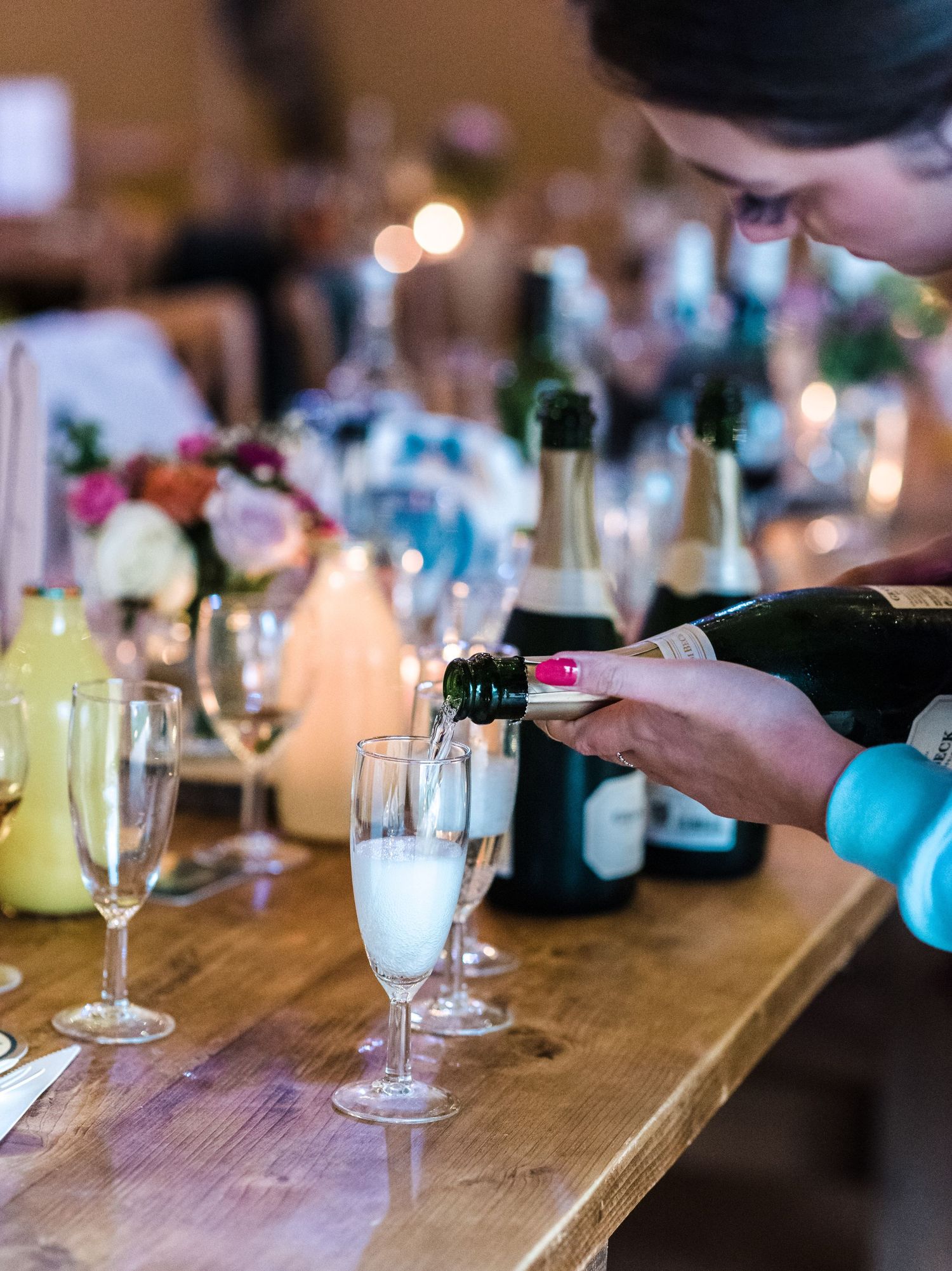 Champagne being poured into glasses at an elegant table setting with candlelight.