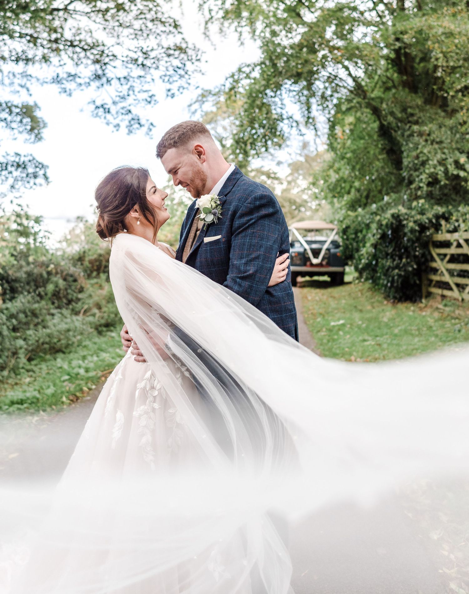 Romantic wedding portrait with flowing veil capturing intimate moment between newlyweds.
