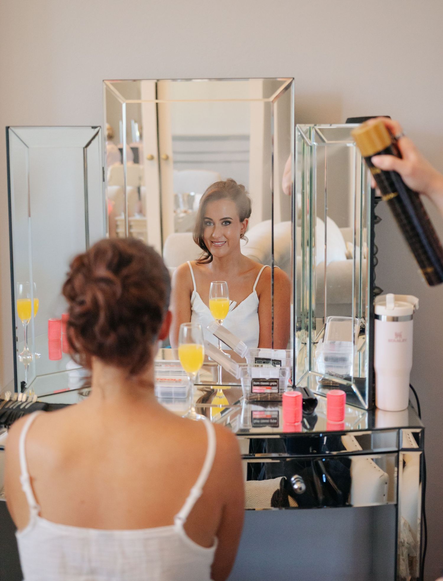 A series of mirror reflections showing a dressing room scene with orange juice on a counter.