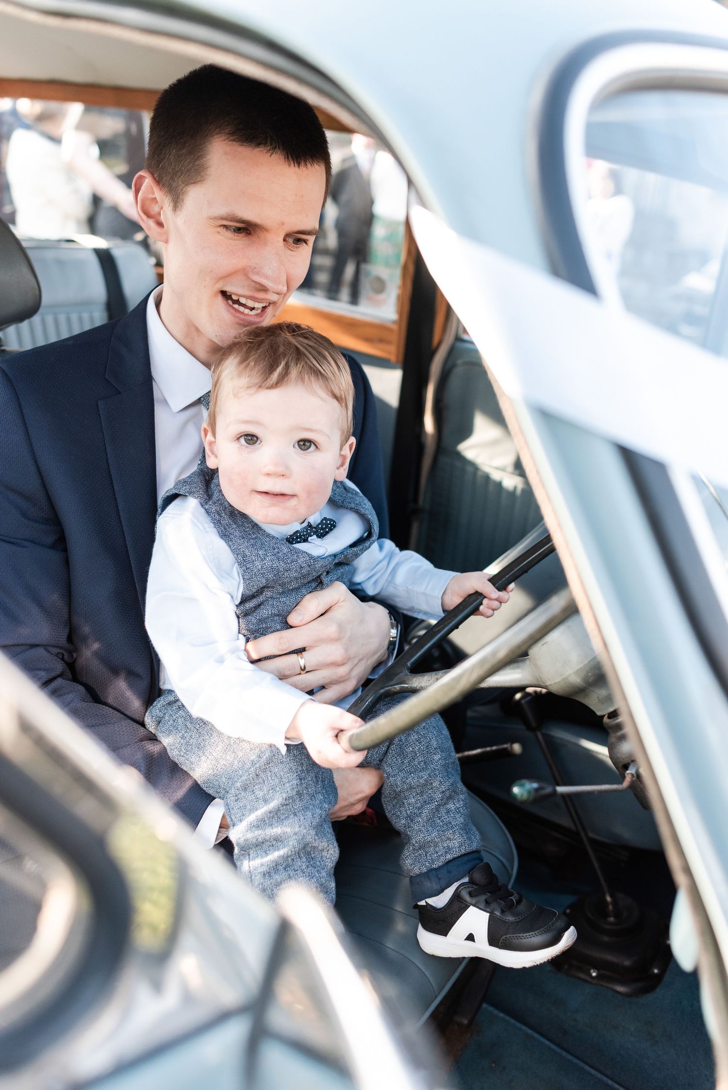 Sweet candid moments captured inside car with toddler during wedding day.