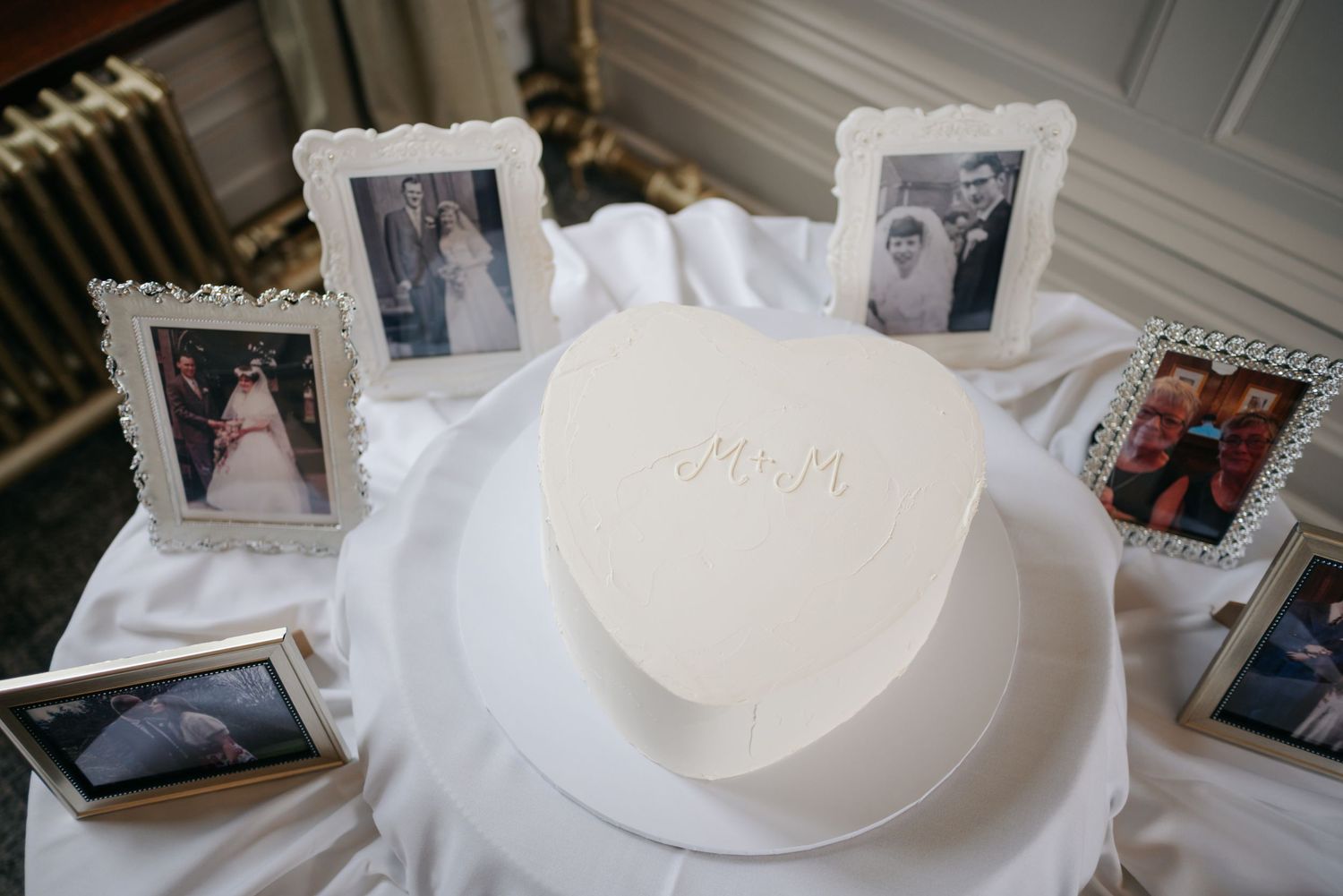 Wedding memory display with framed photographs and white decor elements.