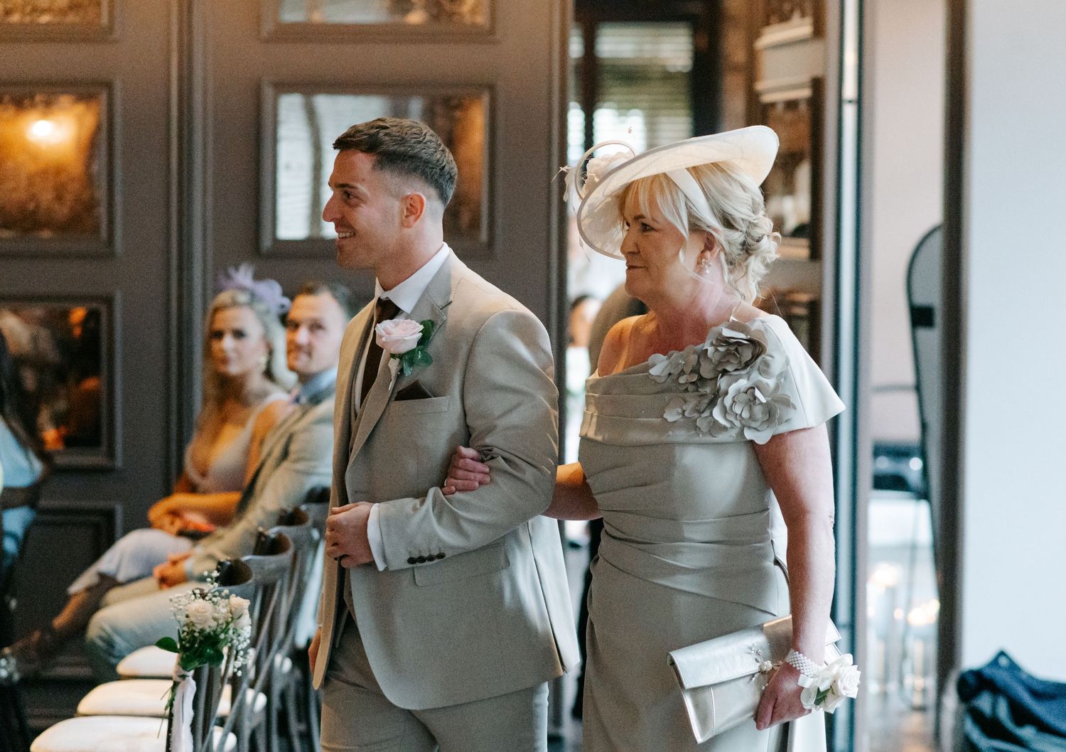 Wedding party members in formal attire gathered in an elegant indoor venue.