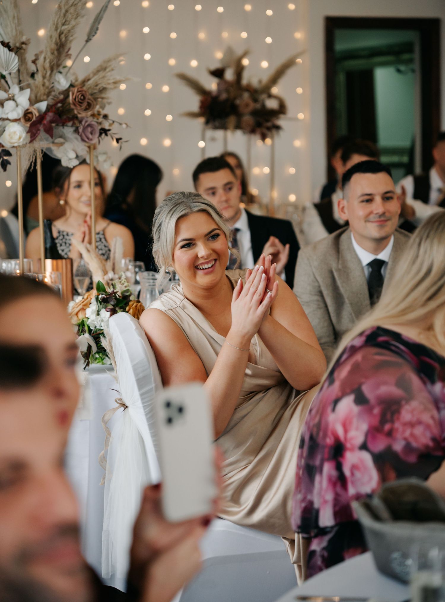 Wedding reception venue decorated with string lights and floral centerpieces creating a warm atmosphere.