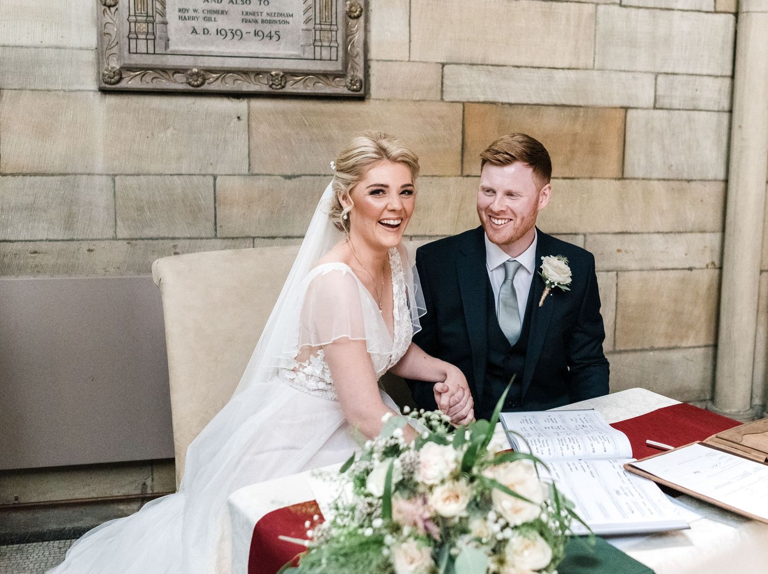 A couple sharing a candid moment while signing their marriage certificate.