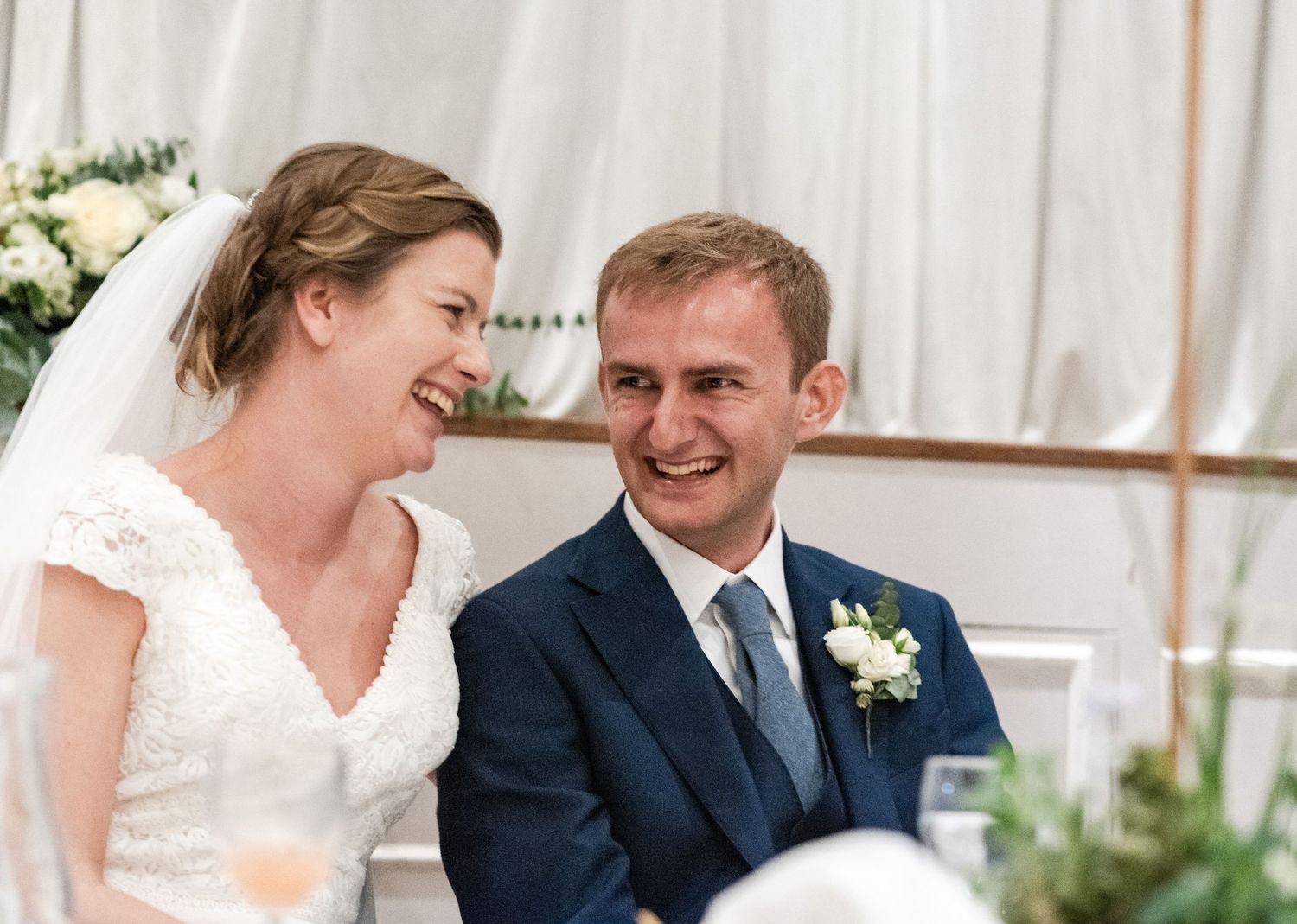 A couple shares an intimate moment during their wedding ceremony in a bright, sunlit venue.