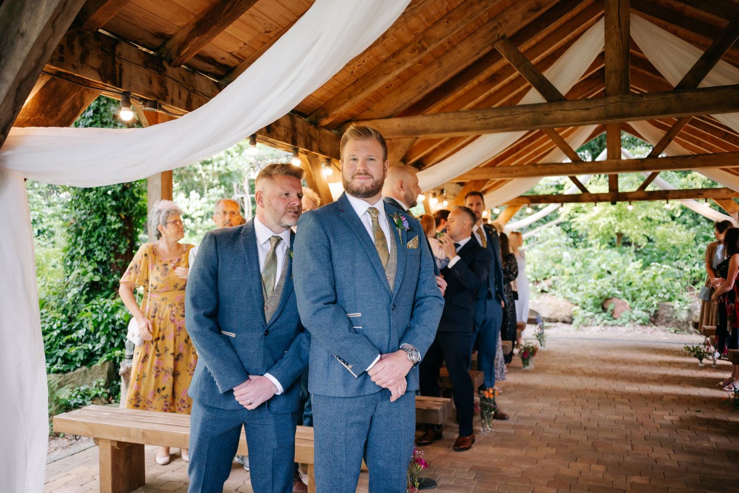 Long covered wooden pavilion with rustic beams and natural lighting for outdoor gatherings.