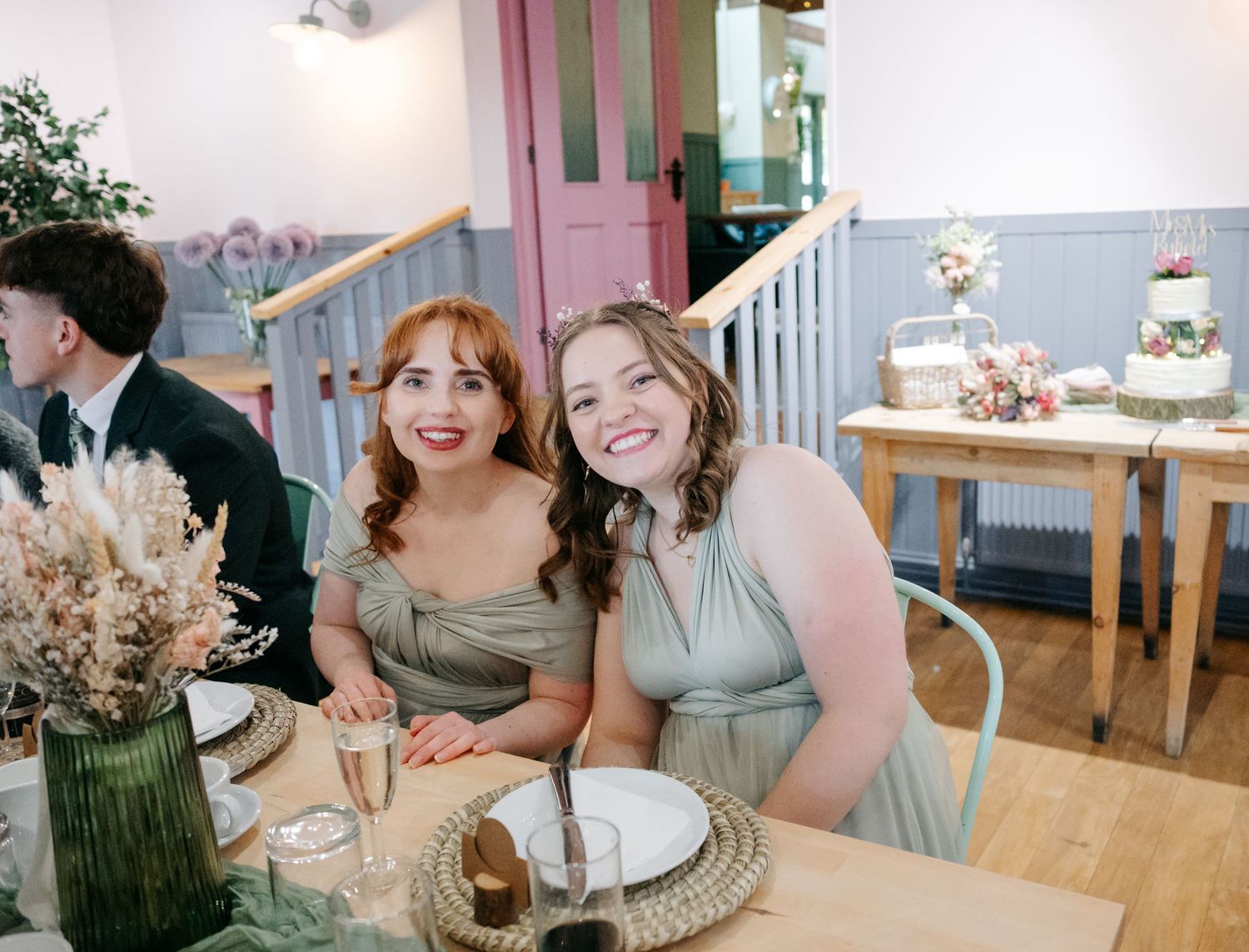 Wedding reception interior with guests seated at decorated tables.