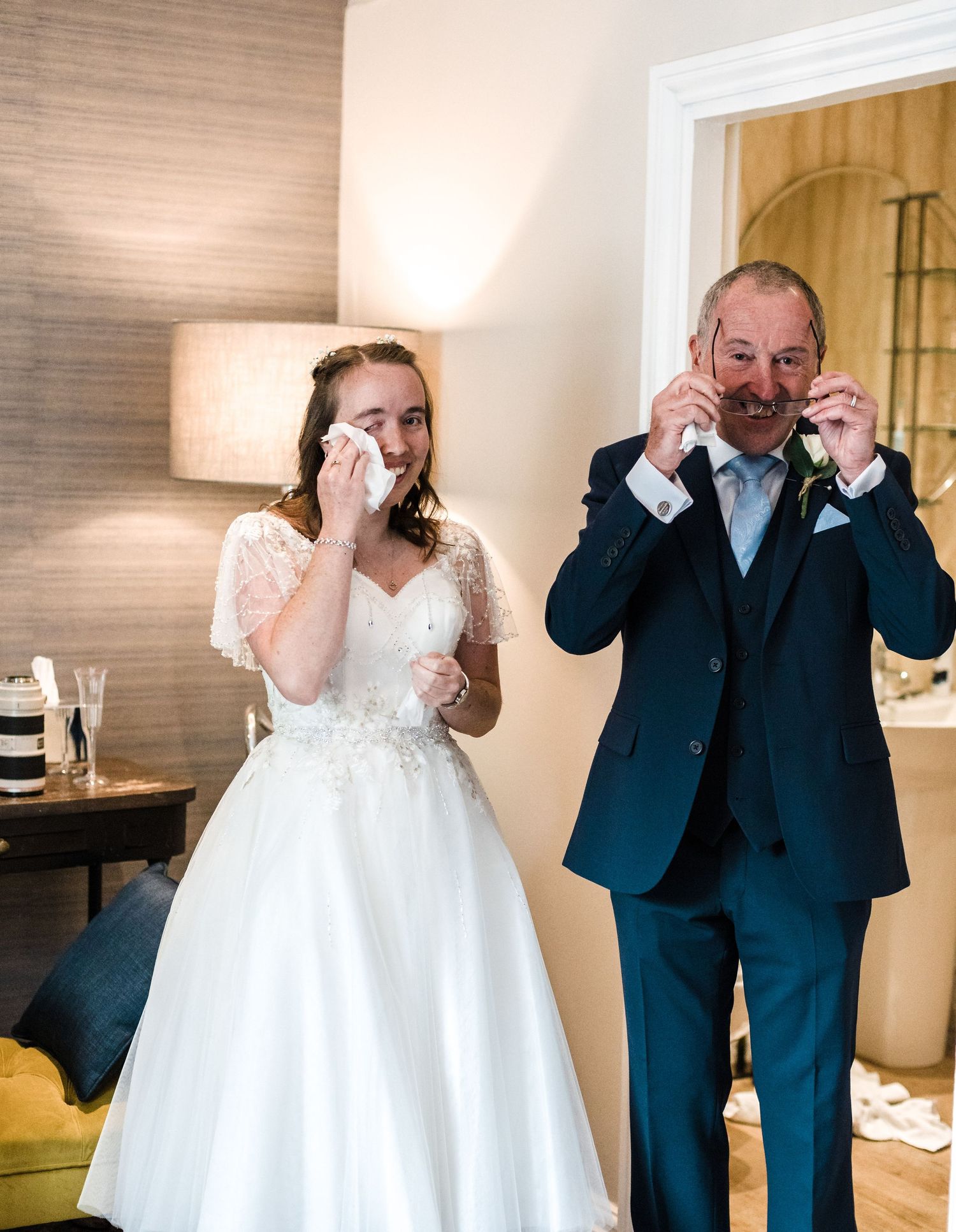 Emotional moment captured as two people wipe tears during wedding ceremony.