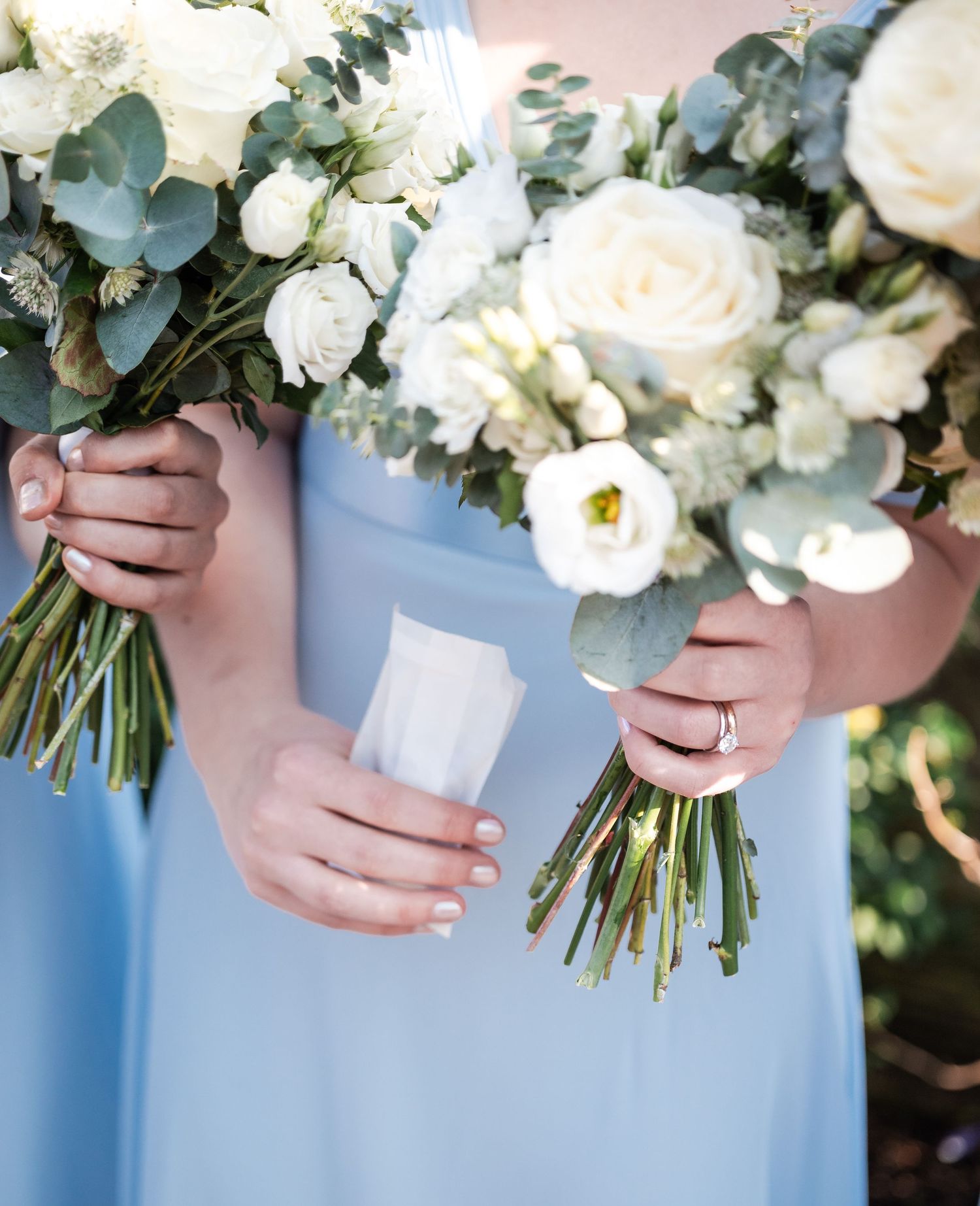 Close-up shots of elegant white and green wedding bouquets with roses and eucalyptus.
