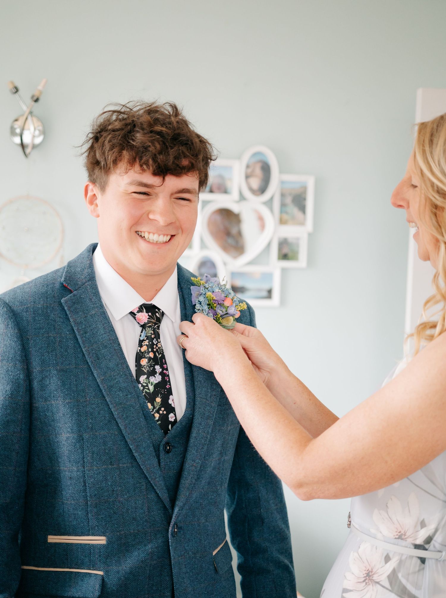 A sequence showing the pinning of a floral boutonniere onto a navy blue suit jacket.